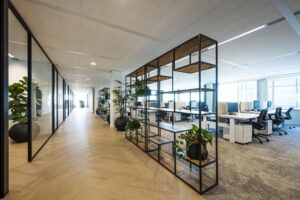 Moderne kantoorruimte aan de Thomas R. Malthusstraat met open werkplekken, glazen vergaderruimtes en planten.